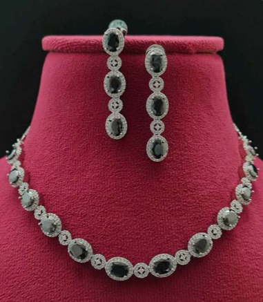 “Cielo necklace and earrings displayed on a velvet red bust with black CZ stones and white plating”
