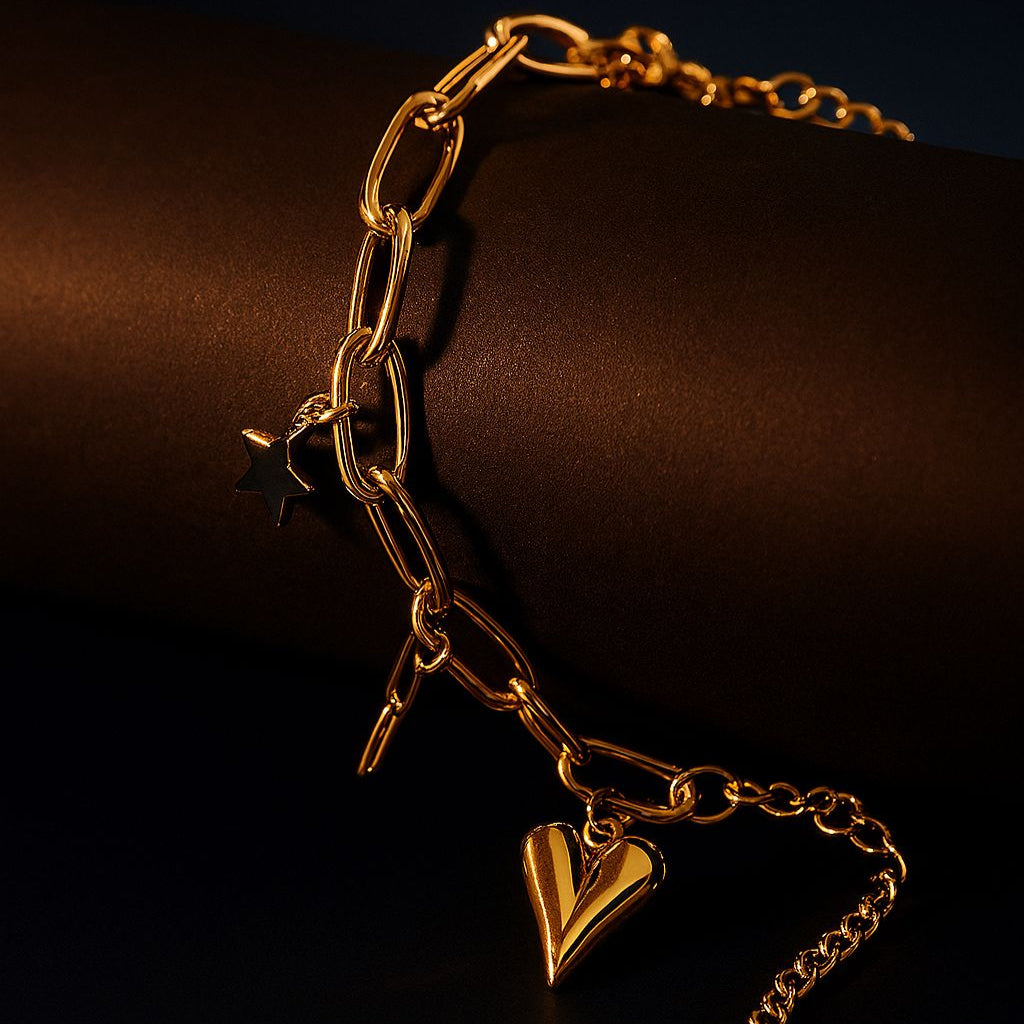 Gold chain bracelet with a heart-shaped charm on a dark background