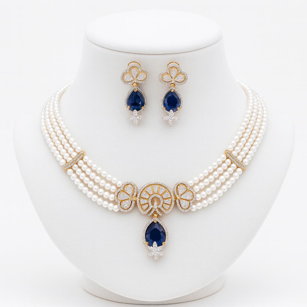 Silvia pearl necklace set on white display stand with gold accents and teardrop blue pendant