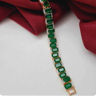 Emerald green CZ bracelet with white rhodium plating, featuring emerald-cut cubic zirconia stones in a classic linear design. Elegant festive jewelry piece by Lavish Jewels.