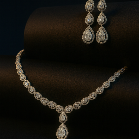 Bellissima Glow necklace set with teardrop CZ stones in white plating, paired with matching earrings, displayed on velvet and bust stand