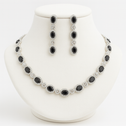 “Cielo necklace and earrings displayed on a velvet red bust with black CZ stones and white plating”

