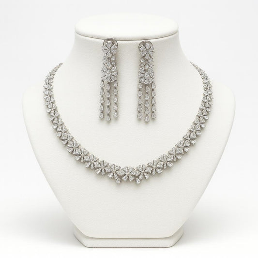 Silver necklace and earrings set on a white mannequin bust.