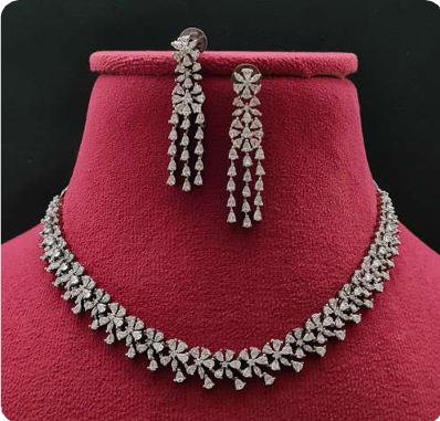 Silver necklace and earrings on a red mannequin bust with a black background