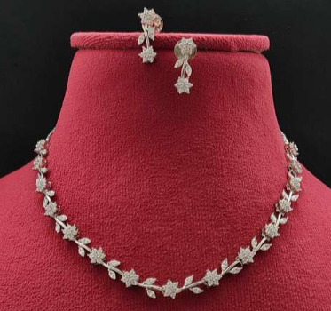 Jewelry set with necklace and earrings on a red velvet stand against a black background