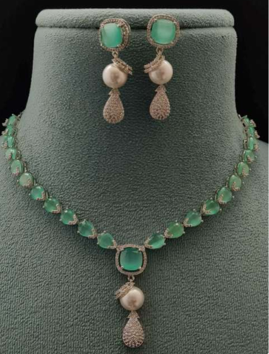 Marina mint pearl necklace and earring set displayed on green velvet bust stand