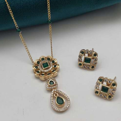 Fancy Kundan Chain with earrings – gold-plated brass jewellery with green kundan stones on black matte cylindrical surface