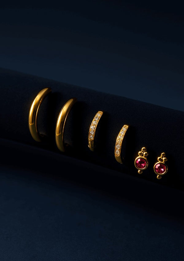 Gold hoop earrings and pink gemstone earrings on a dark background- LAVISH JEWELS