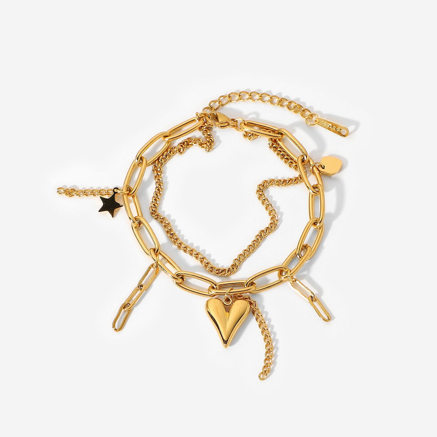 Gold chain bracelet with heart and star charms on a white background