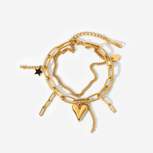 Gold chain bracelet with heart and star charms on a white background