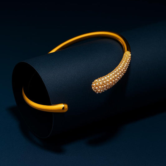 Gold headband with pearl-like embellishments on a dark background