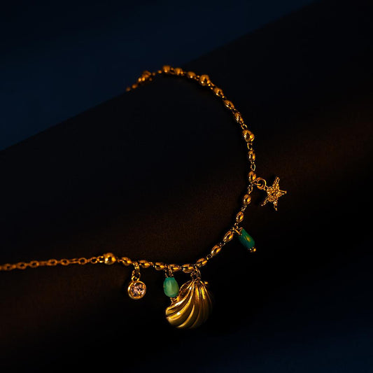 Gold bracelet with charms on a dark background