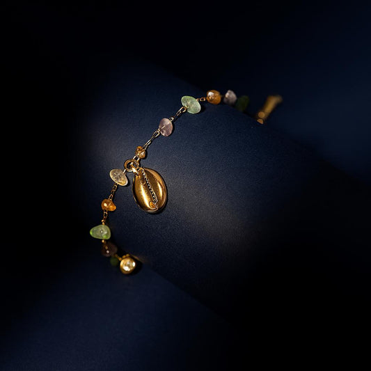 Beaded necklace with gold and multicolored beads on a dark background
