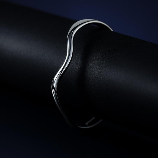 Silver ring on a black surface with a dark background
