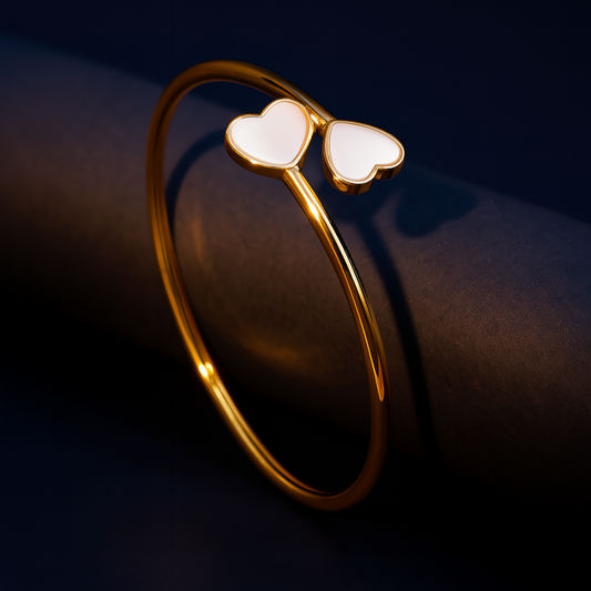 Gold bracelet with heart-shaped ends on a dark background