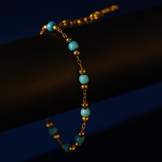 Bracelet with turquoise beads and gold accents on a dark background