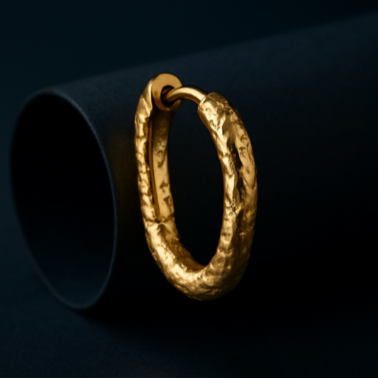 Gold hoop earring on a dark background