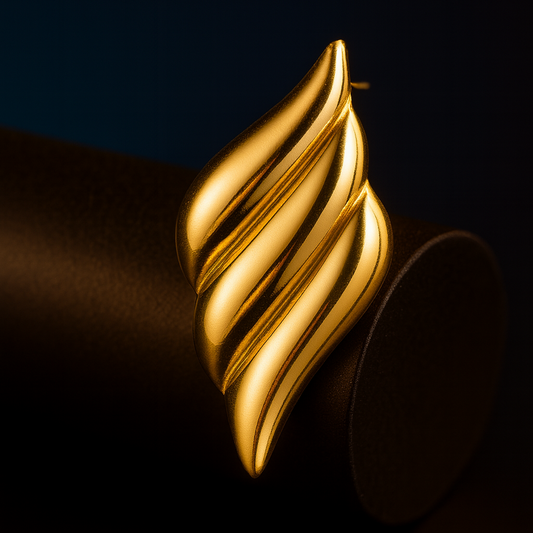 Gold leaf-shaped earring on a dark background