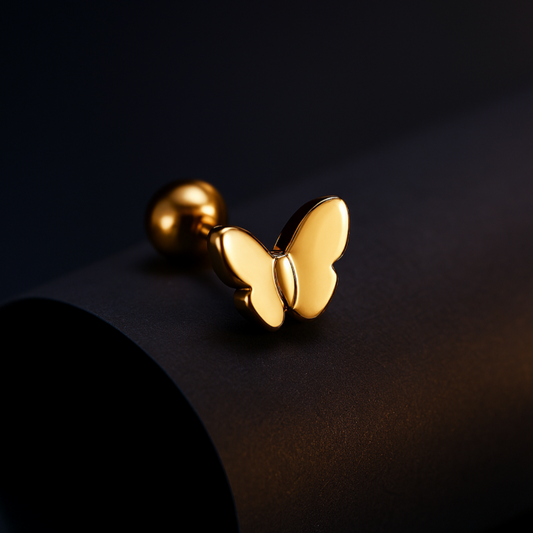 Gold butterfly-shaped earring on a dark background