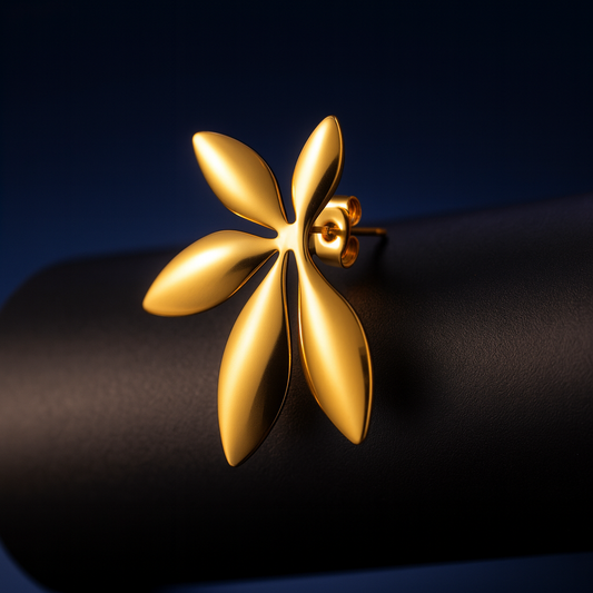 Gold floral earring on a dark background