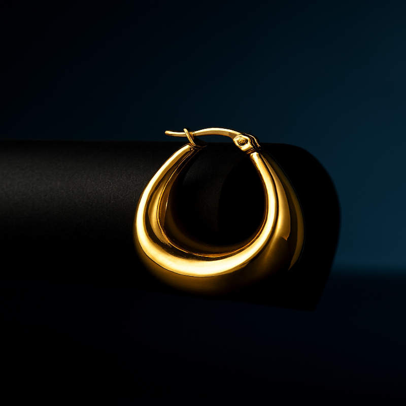 Gold hoop earring on a dark background