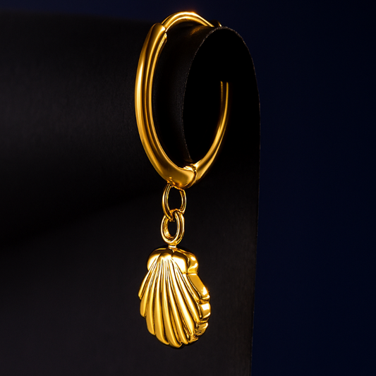 Gold hoop earring with a shell charm on a black background