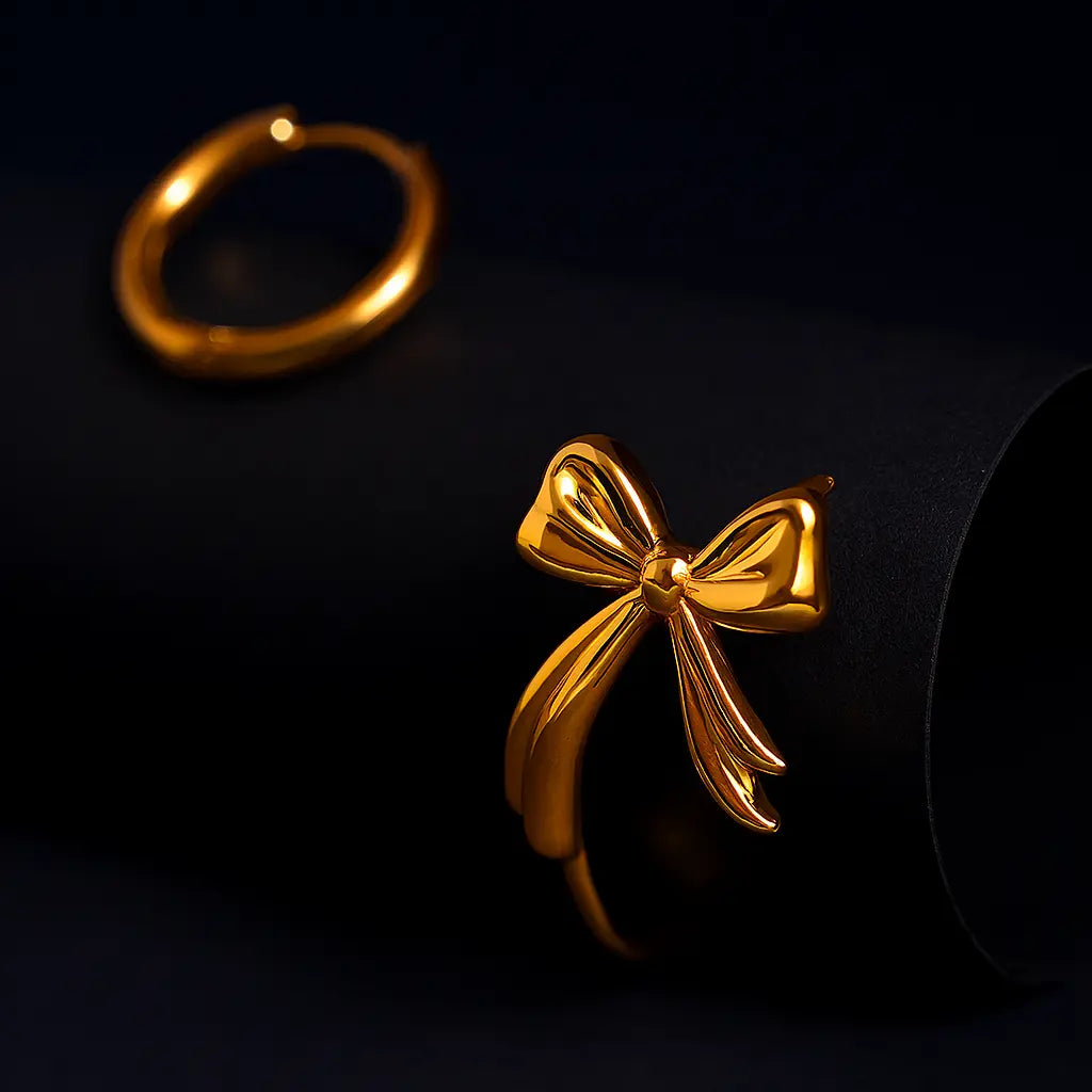 Gold bow-shaped earring on a black background