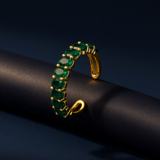 Gold bracelet with green gemstones on a black background