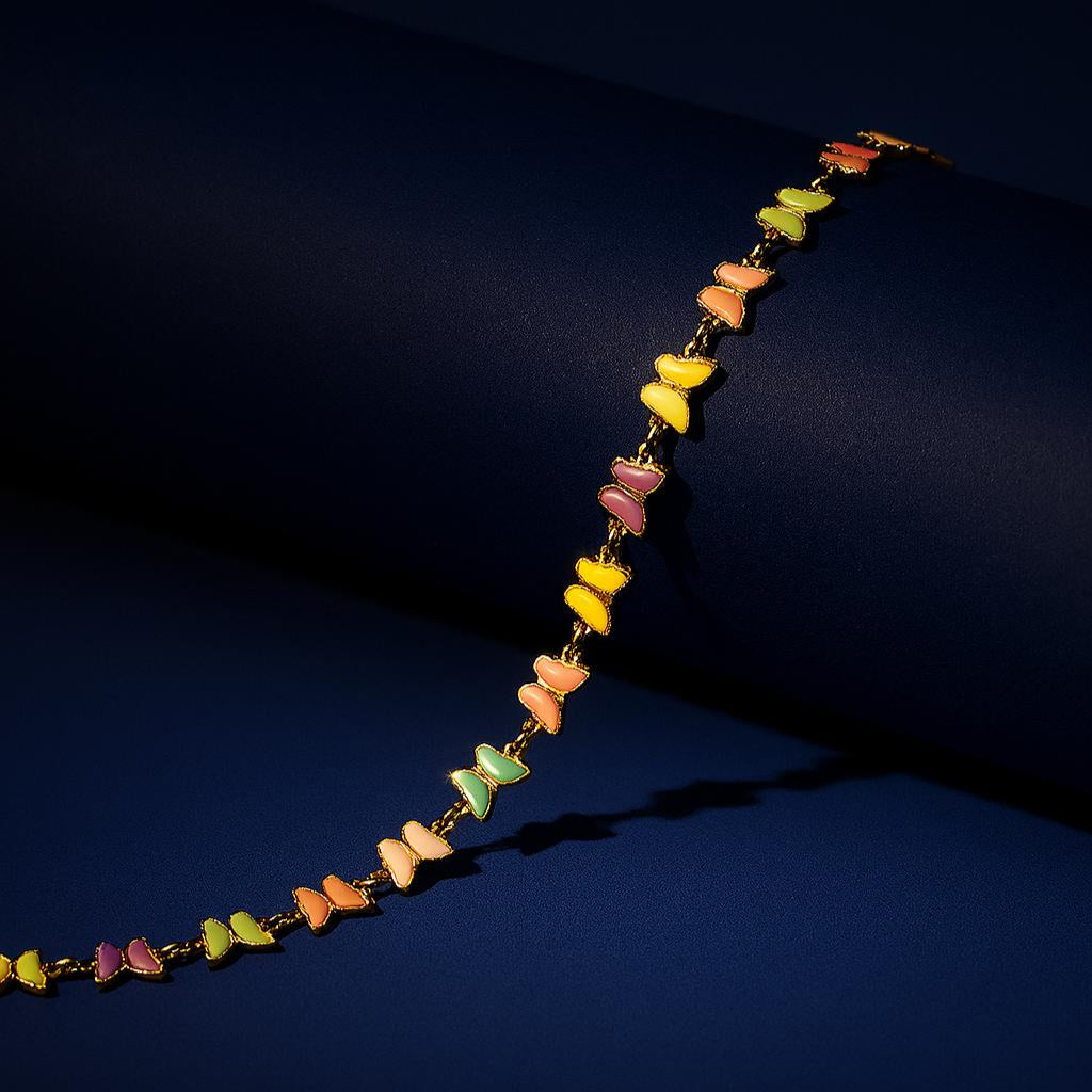 "Butterfly Choker Necklace in 18K PVD gold plated stainless steel with pastel enamel butterflies on dark cylindrical surface with navy background"