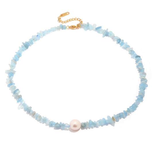 "Luxora Necklace with ocean blue natural stone chips and pearl centerpiece in 18K PVD gold plated stainless steel clasp on white background"