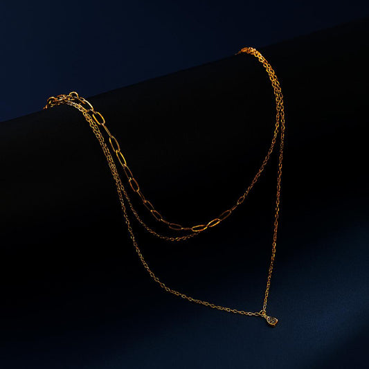 AURENE Gold Necklace with triple layered chains and zircon drop pendant – dark display background