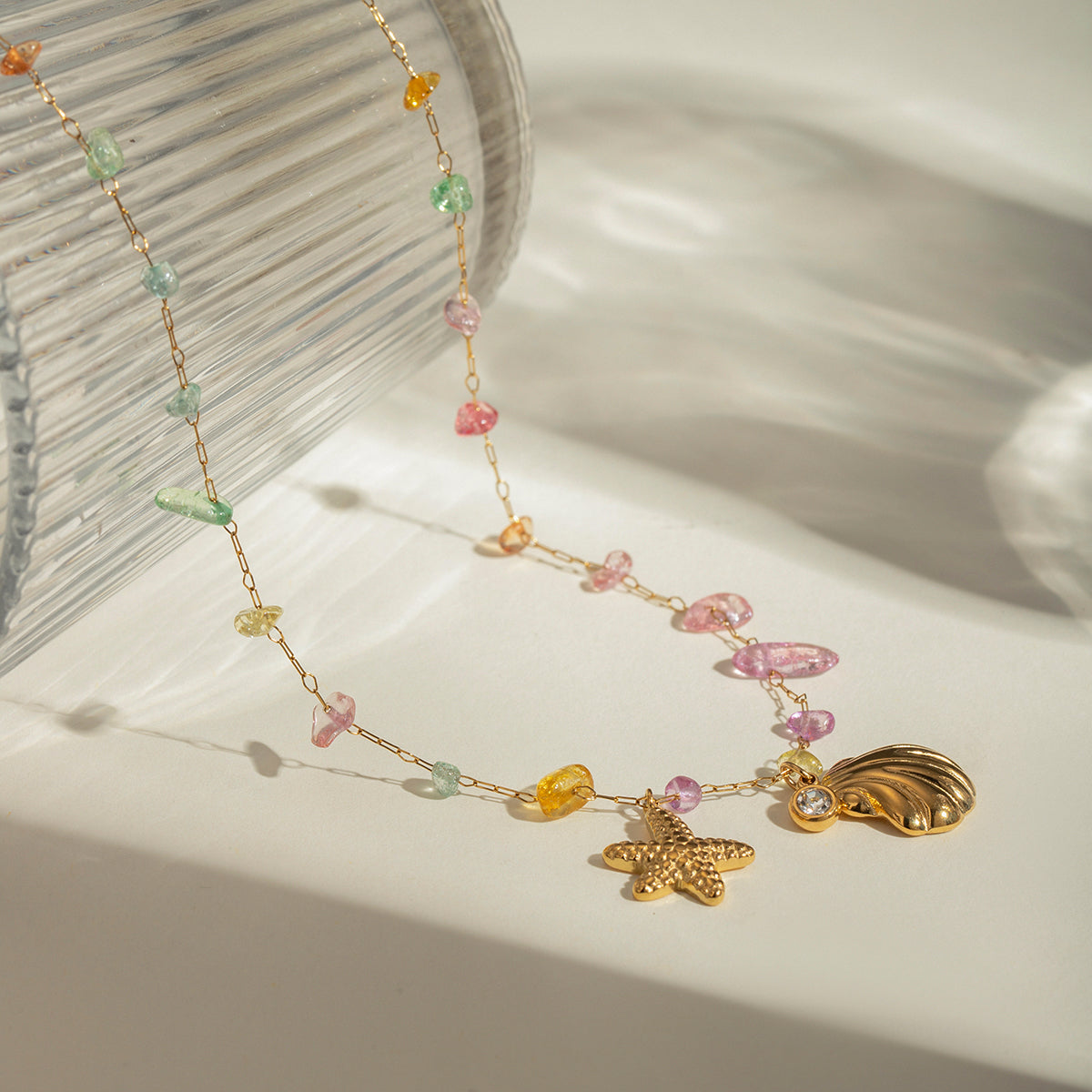 LUX AURA Gold Necklace with shell, starfish, and crystal charms – white background