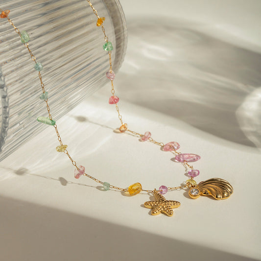 LUX AURA Gold Necklace with shell, starfish, and crystal charms – white background