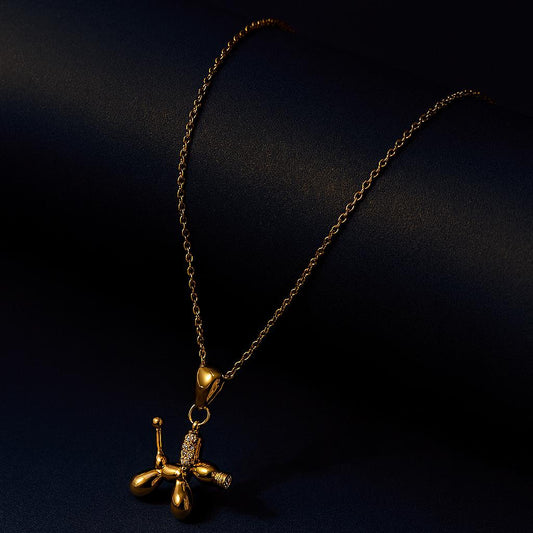 18K PVD gold plated balloon dog pendant with crystals on chain, styled on dark background