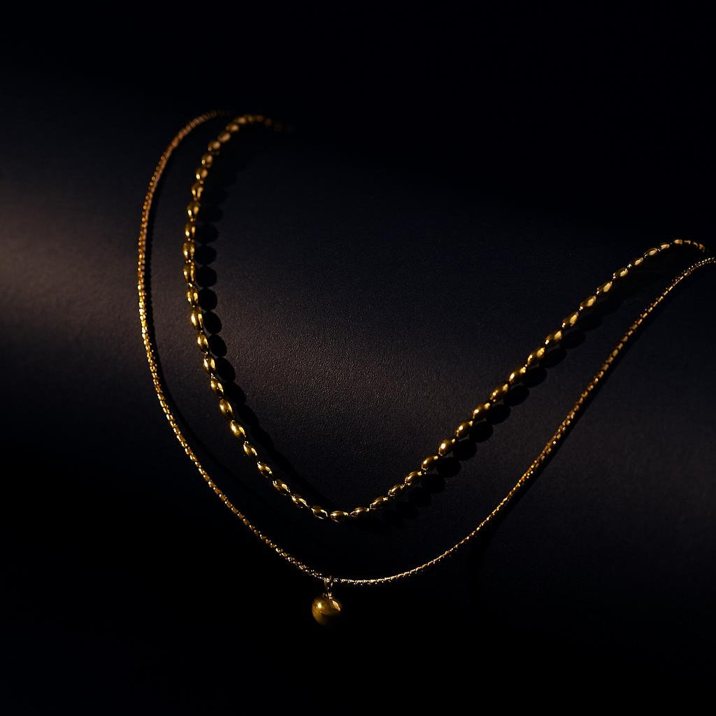 Eden Gold Necklace – double-layer bead chain with disc charm in 18K PVD gold plating on dark background
