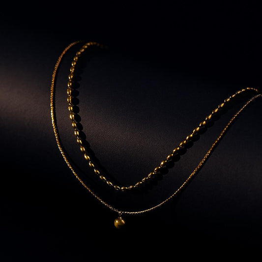 Eden Gold Necklace – double-layer bead chain with disc charm in 18K PVD gold plating on dark background