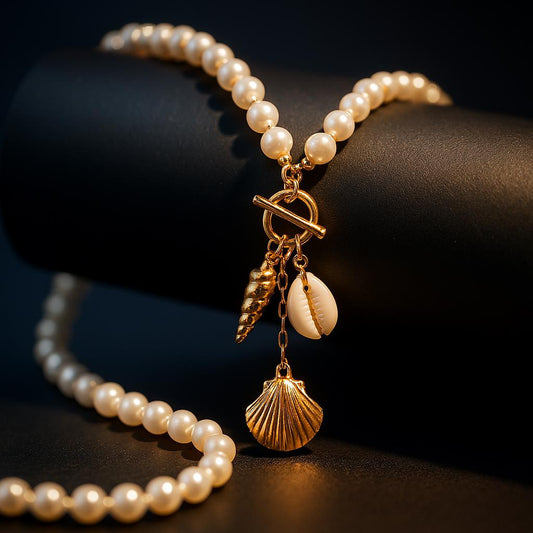 Jade Gold Necklace – pearl chain with seashell charms displayed on black matte roll with navy backdrop