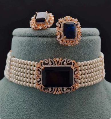 Chiara pearl choker with blue centre stone and matching earrings on green velvet bust