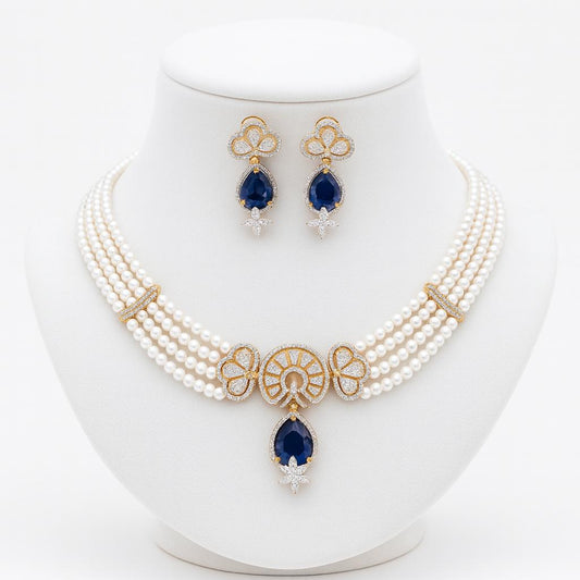 Silvia pearl necklace set on white display stand with gold accents and teardrop blue pendant