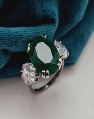Notte Stellata emerald green CZ ring displayed on teal velvet background